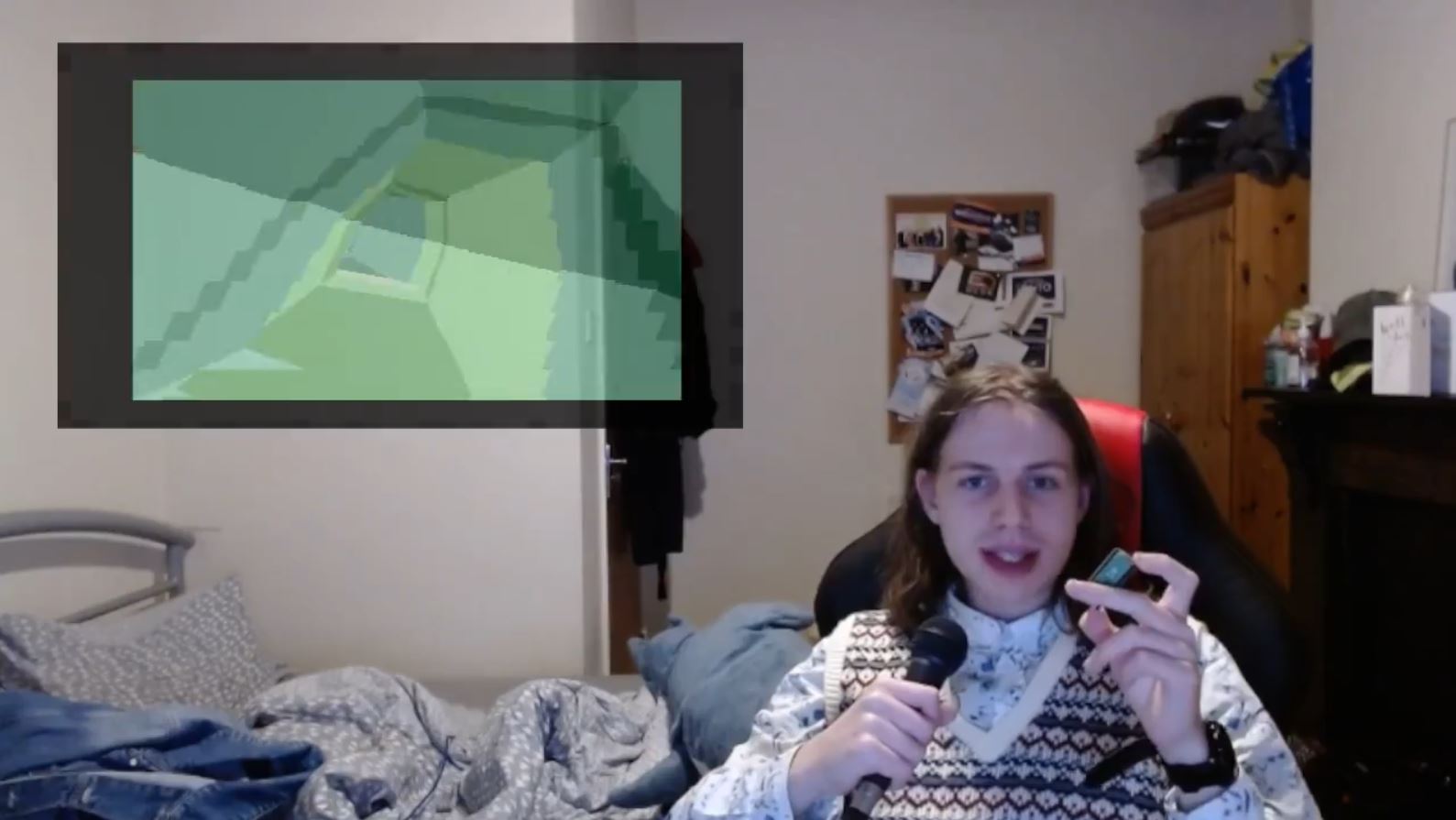 Molive, in their bedroom, holding a Raspberry Pi Pico, with the demo playing picture-in-picture